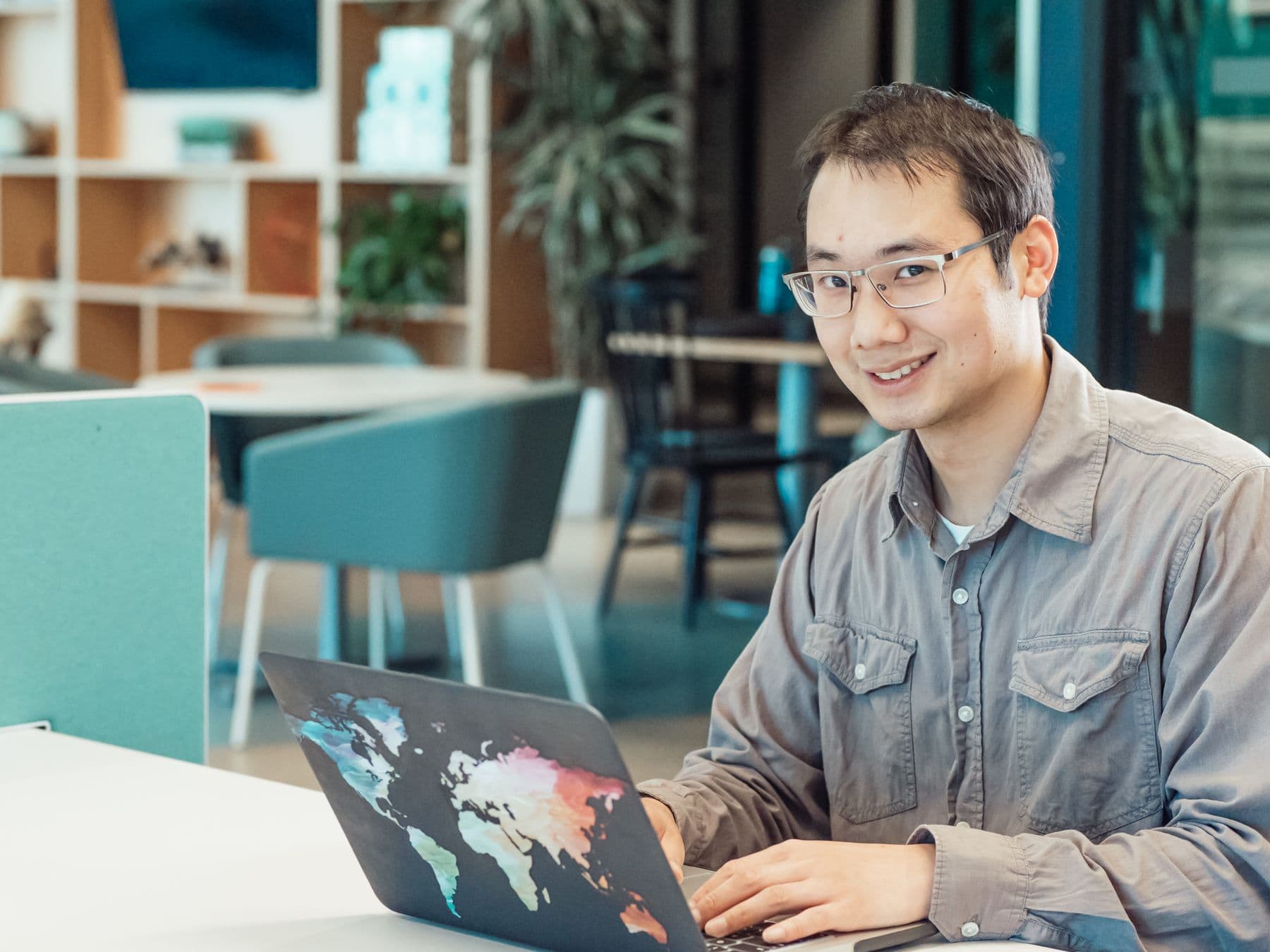 Founder smiling while working on a laptop in a bright studio